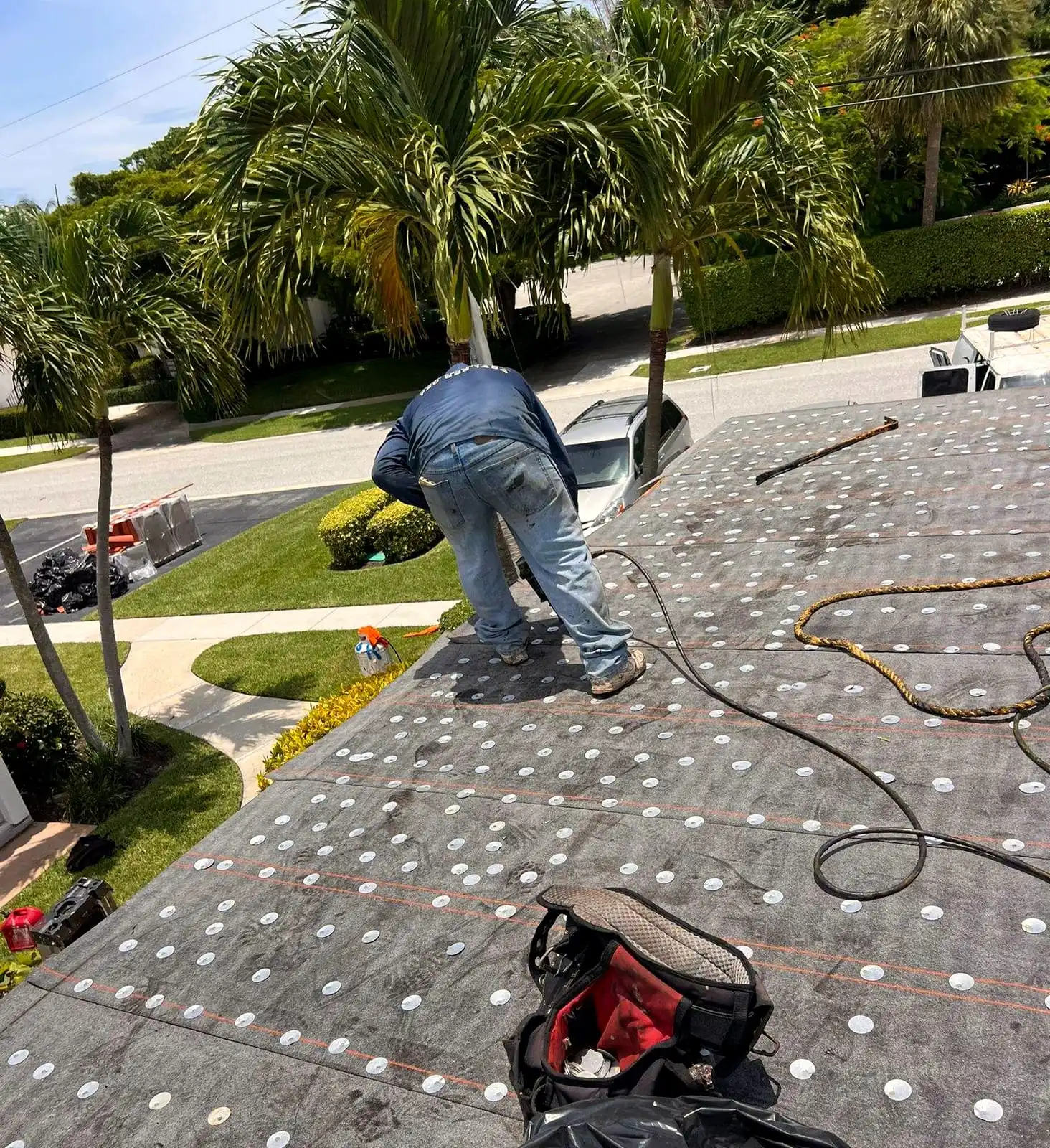 PSR crew member fastening underlayment across a roof deck